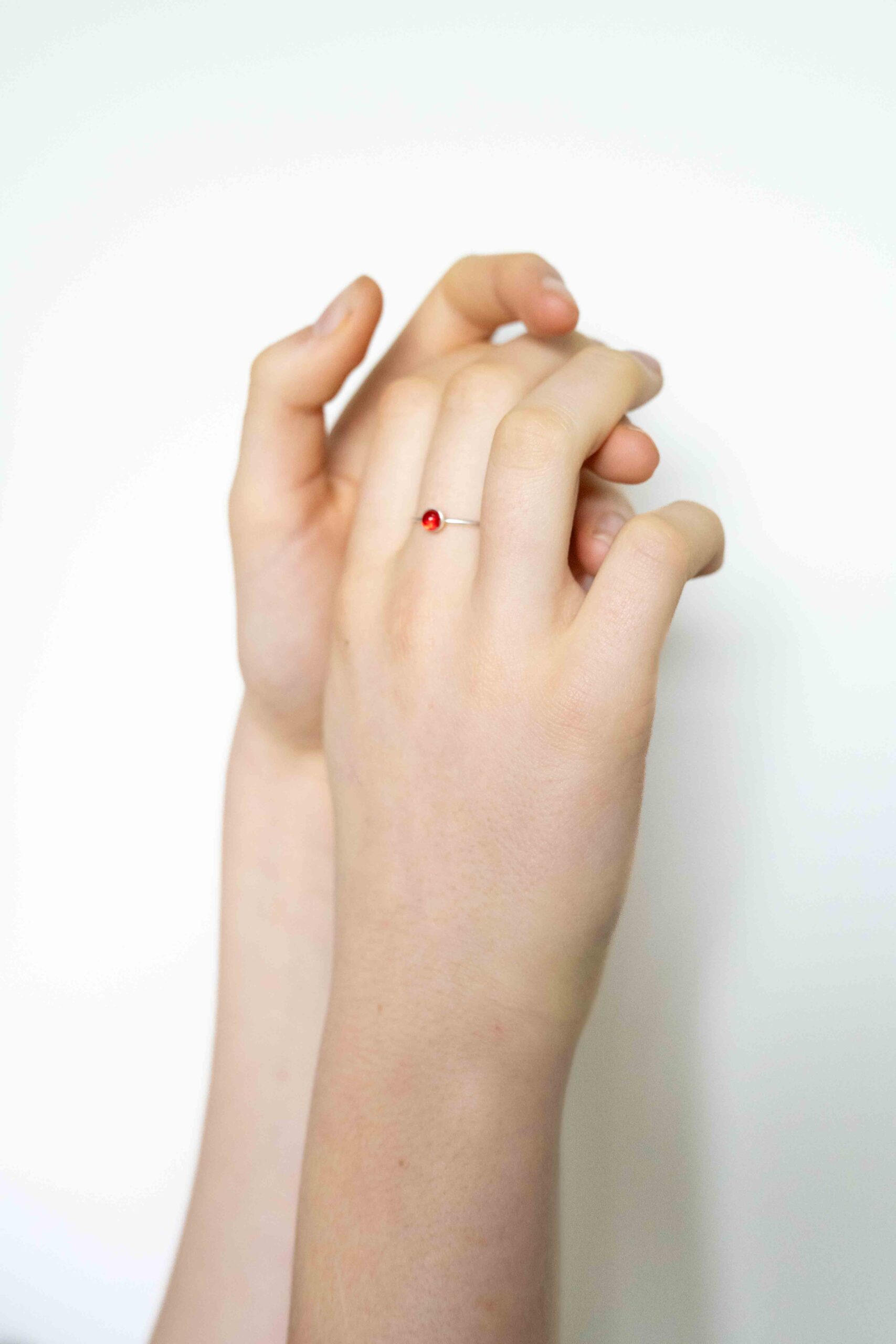 bague mini en verre rouge sur une main